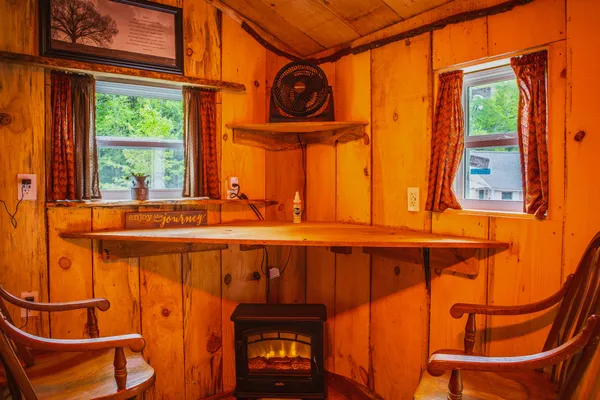 Cozy wood-paneled cabin interior with an electric stove and bar counter