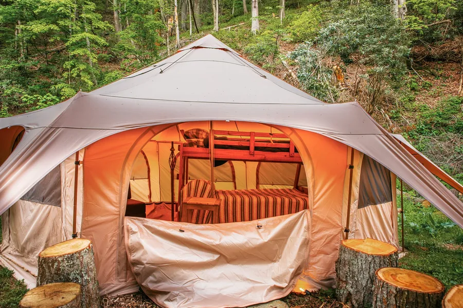 The glamping yurt among the trees, its deck facing out toward the woods