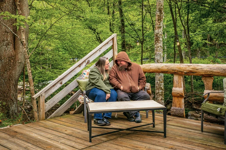 The hostel's thru-hiker hosts on the creekside deck