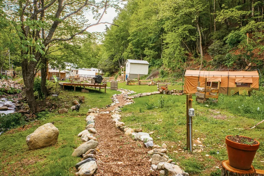 The hostel grounds looking across the field toward the mountains, with the RV spot at the edge of the treeline